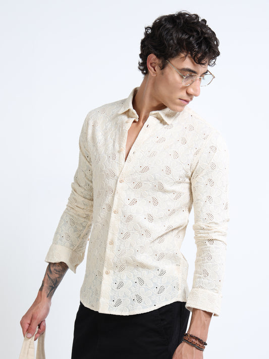 Man wearing a cream-colored patterned shirt on a white background